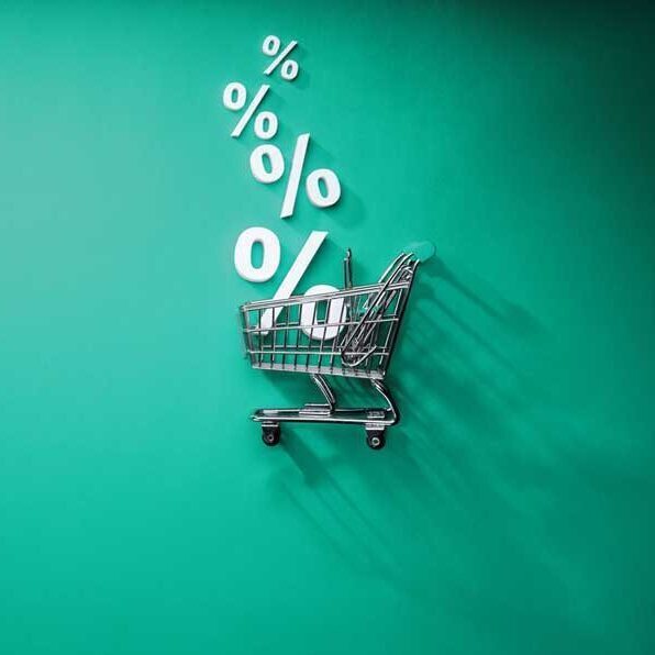 Ein Einkaufskorb auf grünem Hintergrund mit Prozentzeichen