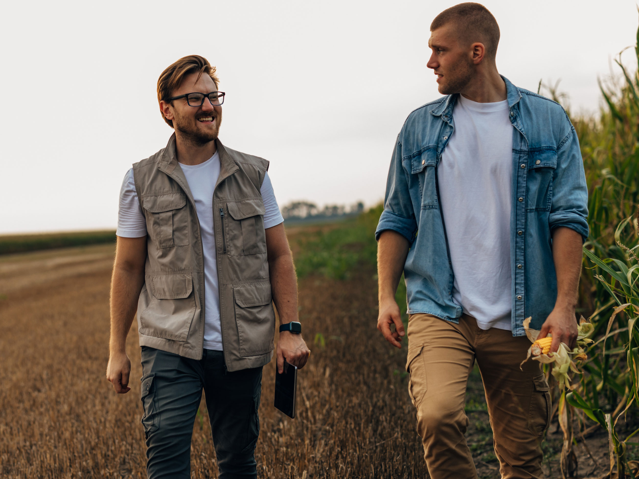 Außendienstmitarbeiter spircht auf dem Feld mit Landwirt