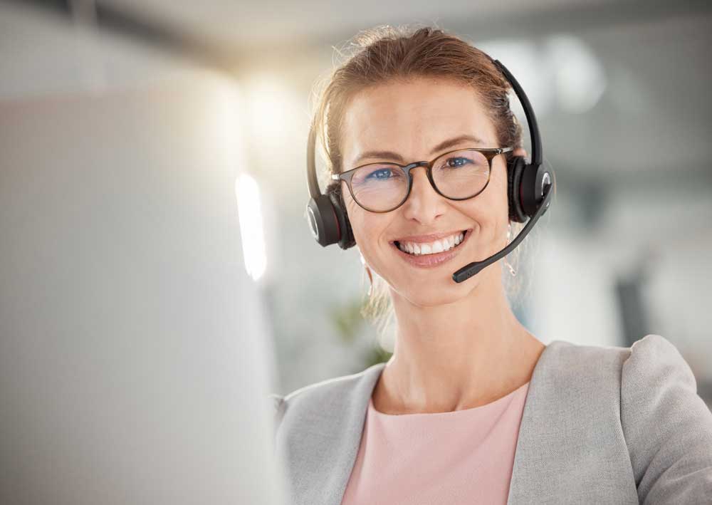 Frau mit Headset lächelt in die Kamera